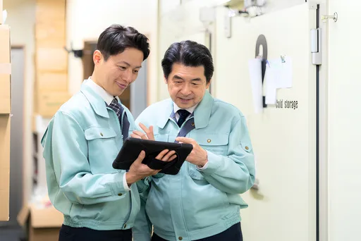 若手とベテランがタブレットを見ながら作業手順を確認している
